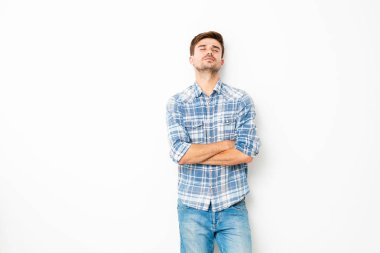 tatlı çocuk, kot pantolon ve kareli gömlek, boş uzayda ile beyaz duvarda duran genç adam hakkında bir şey hayal