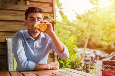 İşten sonra rahatla. Ofis iş sonra bir bira dışında ile terrace adlı genç adam, rahatlatıcı akıllı