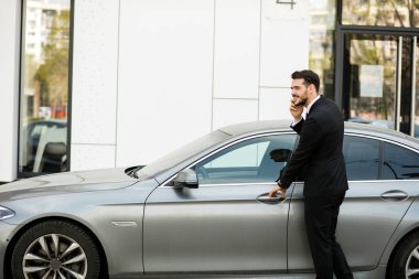 pahalı arabasının içine steping sırasında cep telefonu, konuşan meşgul zarif adam