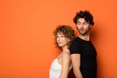turuncu zemin üzerine komik genç çift
