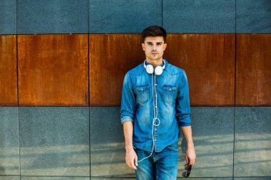 kot pantolon, onun boynuna kulaklıklar ile paslı Duvar ile bir odasında modern adam ile minimalist kavramı