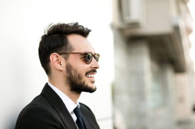 Güneş gözlüklü zarif elbiseli yakışıklı adamın kadar clouse