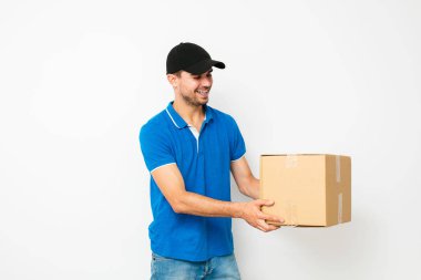 sevinç ve gülümseme, beyaz arka plan ile tarafında paket sunan kibarca teslimatçı