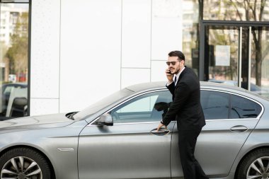 pahalı arabasının içine steping sırasında cep telefonu, konuşan meşgul zarif adam