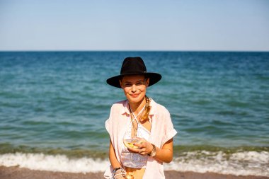 şapkalı bir yaz partide eğleniyor kokteyl ile bir plajda yaz vibe ve parti kız