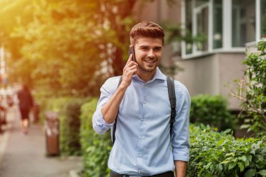 şehirde yaşayan. Sırt çantası cep telefonu konuşurken sokakta ile akıllı casual adam