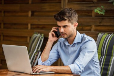 Uzaktan çalışma. yakışıklı delikanlı, blogger veya teras dışında laptop ile uzaktan çalışma