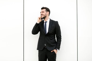 güzel muhabbet cep telefonundan ve gülümseyen, reciving iyi haberler takım elbiseli şık yakışıklı