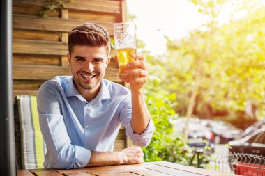 İşten sonra rahatla. Ofis iş sonra bir bira dışında ile terrace adlı genç adam, rahatlatıcı akıllı