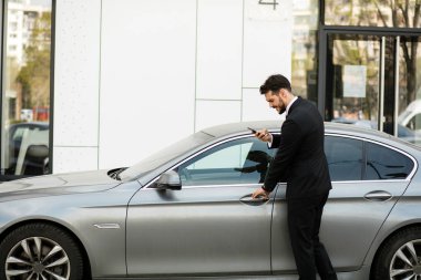 pahalı arabasının içine steping sırasında cep telefonu, konuşan meşgul zarif adam