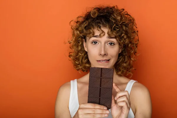 Jonge Expressieve Krullend Vrouw Met Staaf Van Chocolade Een Oranje — Stockfoto