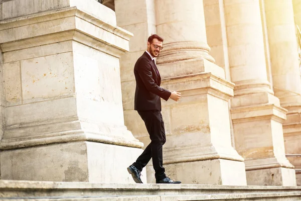 busy elegant stylish man, successful businessman, walking on stairs of important building, university or law court going to an important meeting with confidence