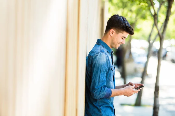 Mladý Student Jeans Oblečení Sms Svůj Mobilní Telefon Usmíval Venku — Stock fotografie