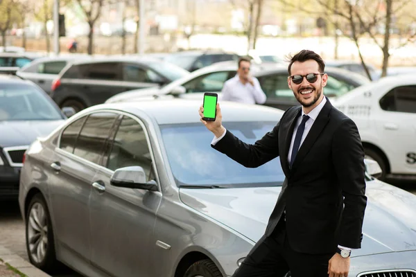 Uber Sterownik Elegancki Garnitur Przed Samochód Luksusowy Pokazując Swój Telefon — Zdjęcie stockowe
