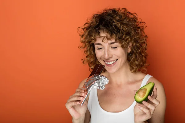 Joven Mujer Rizada Sosteniendo Aguacate Chocolate Las Manos Sobre Fondo — Foto de Stock