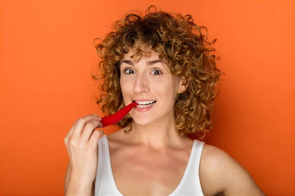 Krullend Jongedame Oranje Achtergrond Met Chili Peper — Stockfoto