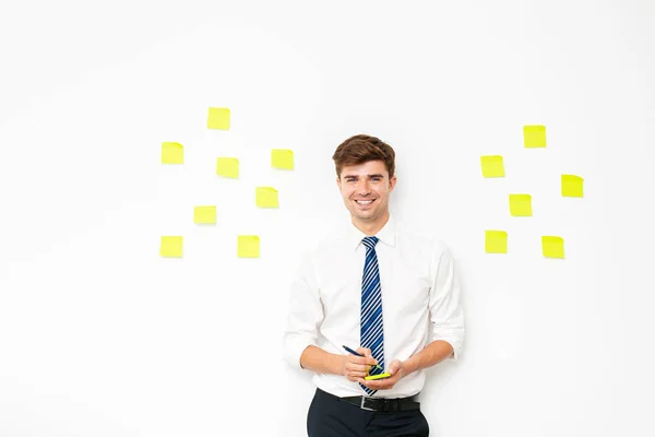 office guy at work, with post it on white wall, reminder notes, plans and  objectives