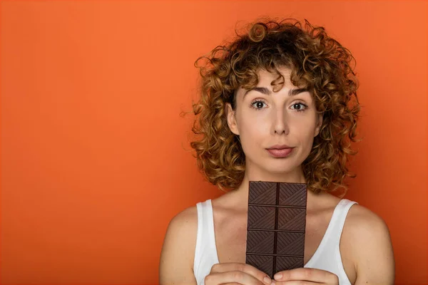 Jonge Expressieve Krullend Vrouw Met Staaf Van Chocolade Een Oranje — Stockfoto