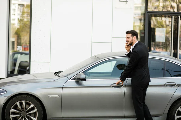 pahalı arabasının içine steping sırasında cep telefonu, konuşan meşgul zarif adam