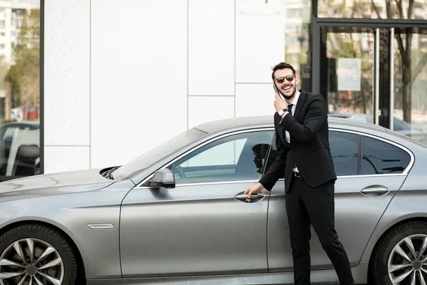 pahalı arabasının içine steping sırasında cep telefonu, konuşan meşgul zarif adam