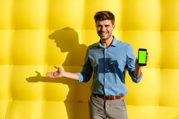 Elegantní Příležitostné Chytráku Mobil Prezentovat Nabídku Jeho Straně Stojící Žlutém — Stock fotografie