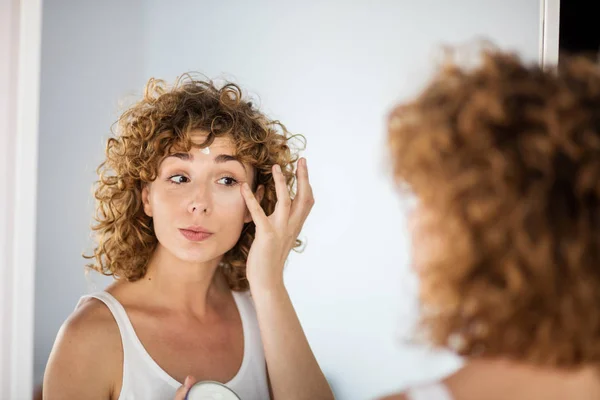 Jovem Mulher Encaracolado Usando Creme Pele Espelho — Fotografia de Stock