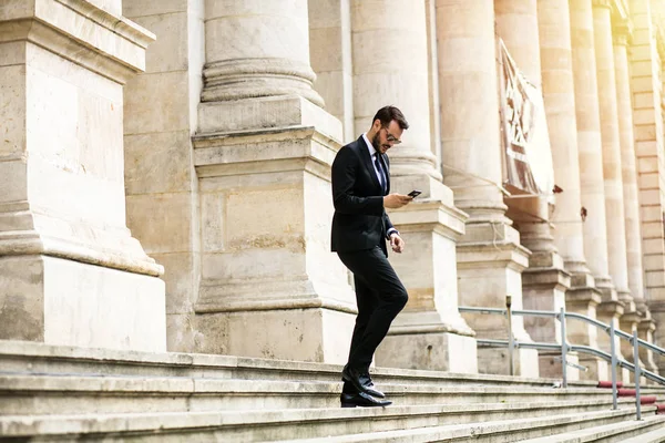 busy elegant stylish man, successful businessman, walking on stairs of important building, university or law court going to an important meeting