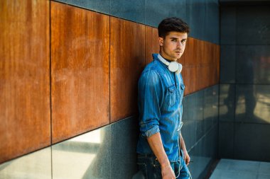kot pantolon, onun boynuna kulaklıklar ile paslı Duvar ile bir odasında modern adam ile minimalist kavramı