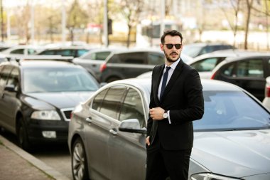 başarılı şık erkek güneş gözlüğü ve şık takım elbise onun limuzin önünde duran ve güven ile seyir