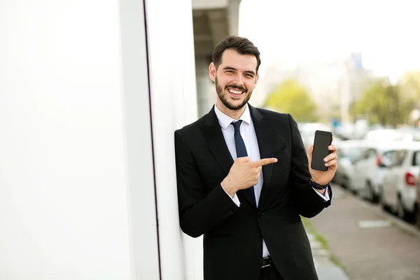Hombre Elegante Guapo Traje Sonriendo Cámara Mostrando Teléfono Celular Afuera — Foto de Stock