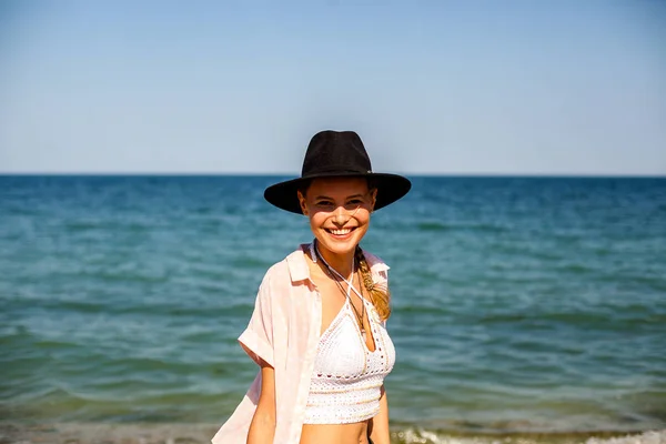 summer vibe and party girl with hat, at a summer party on a beach with cocktail having fun