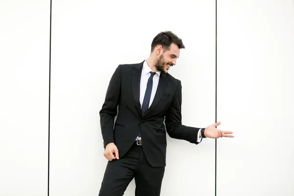 Κομψό Άνθρωπος Στο Κοστούμι Επιχειρηματίας Παρουσιαστής Στέκεται Πάνω Λευκό Τοίχο — Φωτογραφία Αρχείου