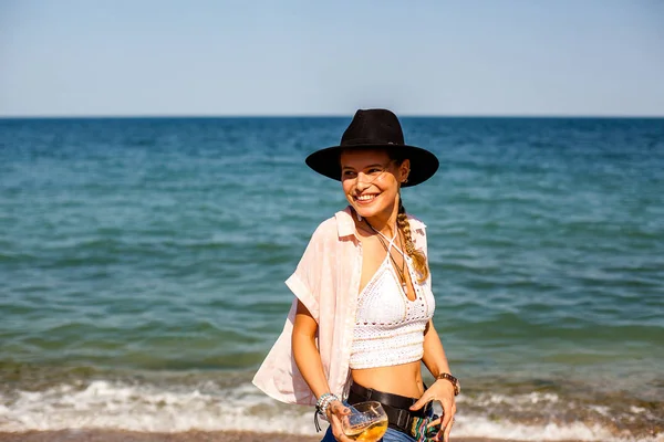 summer vibe and party girl with hat, at a summer party on a beach with cocktail having fun