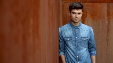 Kameraya gülümseyen seyir kot giymiş yakışıklı genç elbise