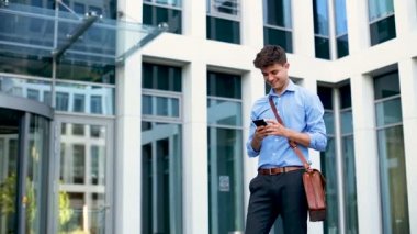 cep telefonu ayakta ofis binası karşı kullanma yakışıklı genç 