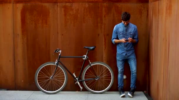 Schöner Junger Mann Tippt Auf Handy Das Neben Fahrrad Steht — Stockvideo