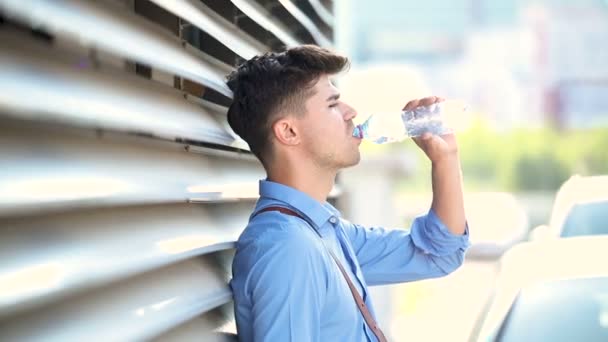 壁や飲料水で傾いている疲れの若い男 — ストック動画