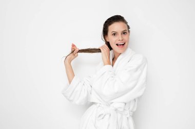 kamera için onun saç beyaz zemin üzerine bornoz gösteren genç doğa ve güzellik kadın saç tedaviden sonra mutlu