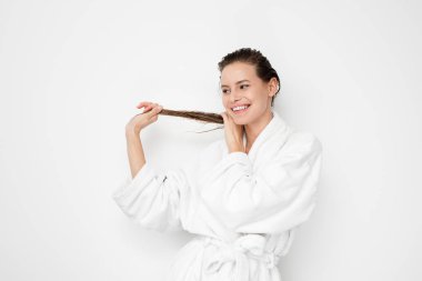 kamera için onun saç beyaz zemin üzerine bornoz gösteren genç doğa ve güzellik kadın saç tedaviden sonra mutlu