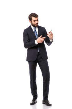 Kurumsal adam, zarif işadamı cep telefonunu tutan ve üzerinde boş tarafını işaret eden beyaz arka plan üzerinde duran