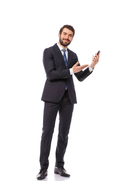 公司的人 优雅的商人站在白色的背景拿着他的手机 指着空的一面 — 图库照片