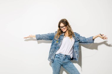 müzik ve dans için dinle. güzel bir kadınla genç etkileyici kulaklık ile müzik ve dans, beyaz arka plan üzerinde retro kot kıyafeti kavramı