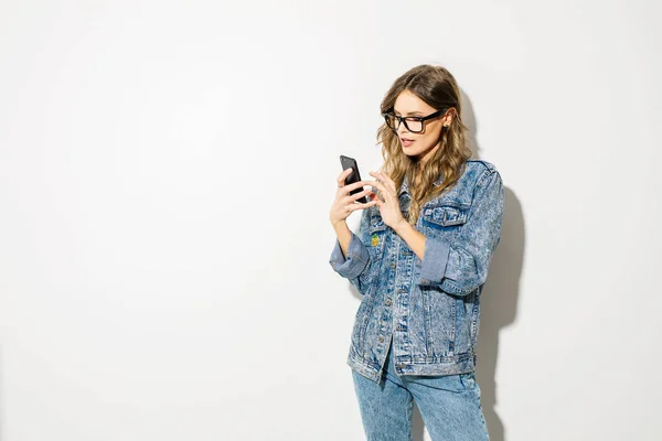 Genç Kadın Akıllı Telefonu Beyaz Arka Plan Üzerinde Seyir Kot — Stok fotoğraf