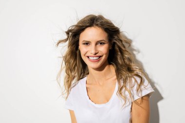 Genç ve güzel bir kadın, beyaz gömlekli kameraya gülümseyen ifade yüz portresi