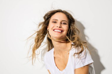 Genç ve güzel bir kadın, beyaz gömlekli kameraya gülümseyen ifade yüz portresi