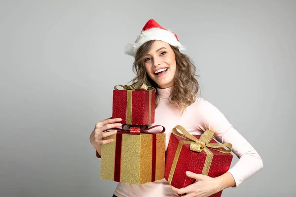 非常幸福的女人与圣诞帽手中持有许多礼物 — 图库照片