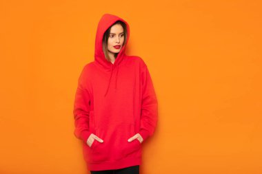 poz ya da bir şey bekliyor serin genç hipster sarı zemin üzerine kırmızı kukuletalı baş başlık ile