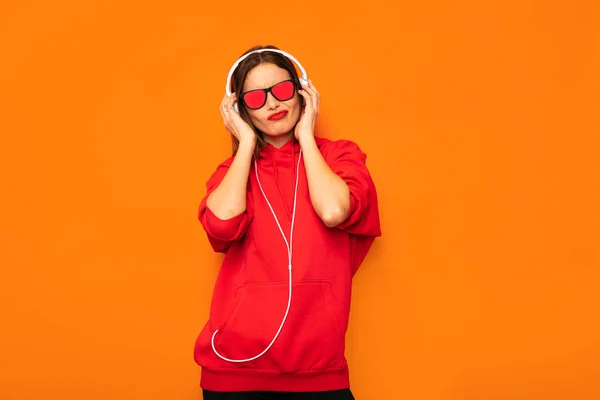 Jonge Rebel Meisje Rode Hoodie Met Hoofdtelefoons Zonnebril Luisteren Muziek — Stockfoto