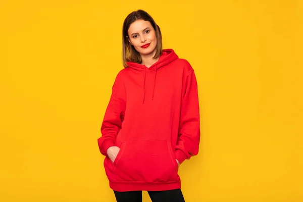 hipster kadın sarı zemin üzerine kırmızı kapüşonlu ile poz güzel genç kadın