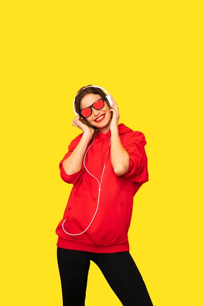 Jonge Rebel Meisje Rode Hoodie Met Hoofdtelefoons Zonnebril Luisteren Muziek — Stockfoto